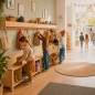 Preview: Kinder spielen und lernen selbstständig an Montessori Holz-Garderobe im warmen skandinavischen Kinderzimmer