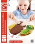 Preview: ädchen spielt mit dem Hape Kantinenschmaus E3141 Holzspielzeug-Set und schneidet ein Holz-Steak mit Messer und Gabel