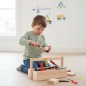 Preview: Ein Kind arbeitet konzentriert mit dem Kinder Werkzeugkasten FREDDY aus Holz und schnitzt sicher an einem Holzklotz.