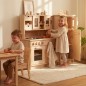 Preview: Kinder spielen an der Kinderküche Hänsel Set mit Backofen, Schrank und Arbeitsplatte aus Holz.