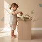 Preview: Kinderküche Kita Montessori aus Holz - Kleinkind Mädchen schüttet Wasser in das Waschbecken