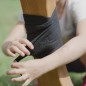 Preview: Dem Voltipferd Holzpferd werden von einem Kind schoene Bandagen an den Beinen angelegt.