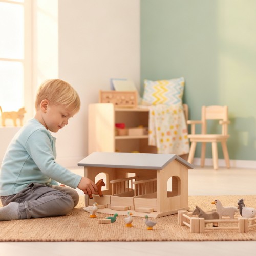 Kind spielt mit dem Pferdestall Lisa von Holzspielzeug Peitz