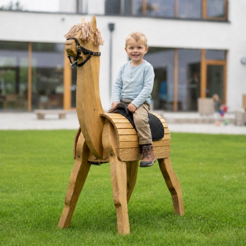 Kind sitzt glücklich auf einem handgefertigten Holz Alpaka im Garten mit Outdoor-Spielatmosphäre.