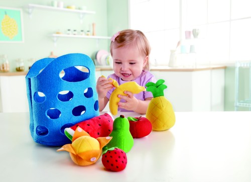 Mädchen spielt mit dem 8-teiligen Obstkörbchen-Set aus Stoff von Hape