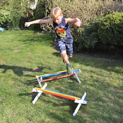 Hindernis Hürde für Kinder im Garten – aktives Spielen mit Hobby Horse, fördert Bewegung und Koordination