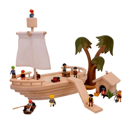 kinder-piratenschiff aus massivem holz mit Segelmast, mastkorb und segel, Variante ohne Deck, Kajütenhaus als Kapitänshaus an Land mit Holz-Deko-Palmen und Playmobil Piraten und Boot