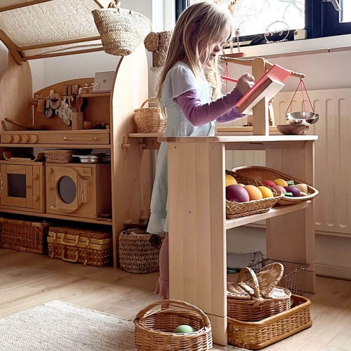 Kind spielt an Holz Spieltheke – kreatives Rollenspiel im Spielhaus