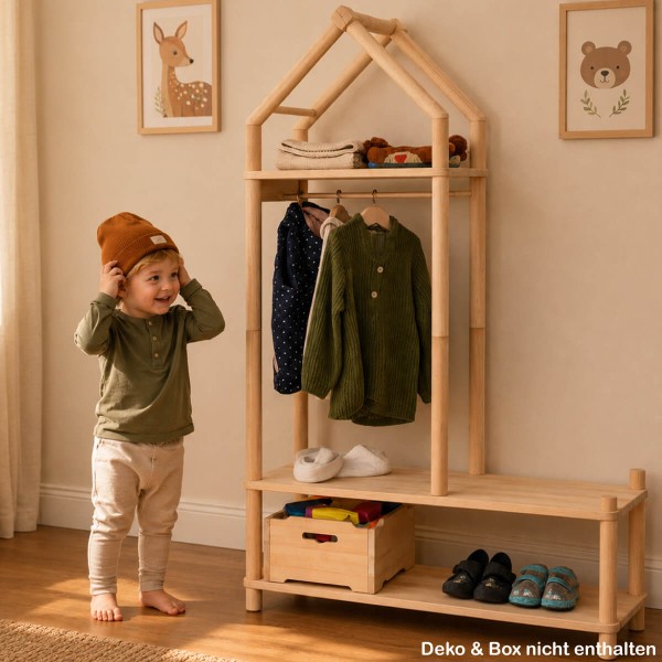 Kind setzt Mütze an Montessori Garderobe auf und lernt selbstständiges Anziehen im Flur