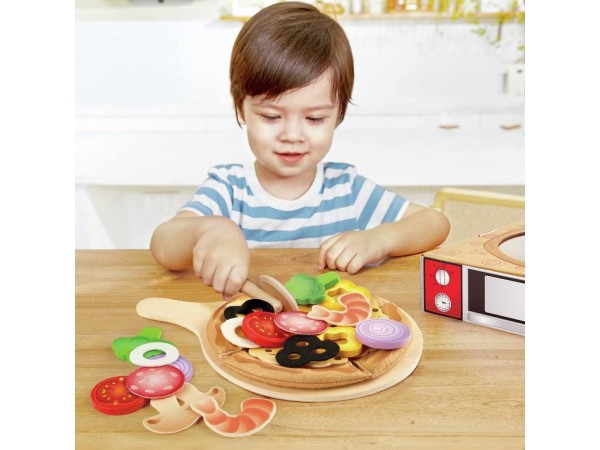 Spielendes Kind beim schneiden der Spielzeug Pizza