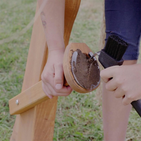 Putz Hufe für Holzpferde - Kind kratzt Hufe aus