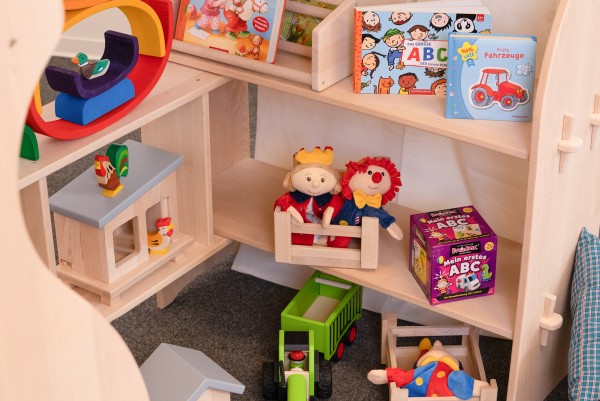 Huehnerstall mit Hühnern im Spielständer, mit Kisten, Büchern und Püppchen